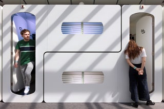 two people standing in the doorway of a pod hotel