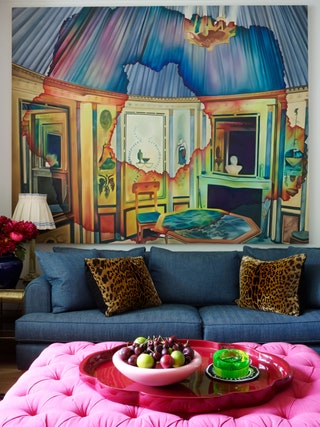 living room with artwork and pink ottoman