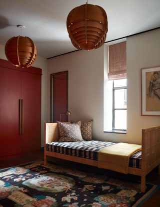 Dressing room with daybed beneath narrow window pink wardrobe to left two hanging light fixtures