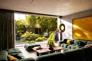big green sofa in living room open to outdoor space