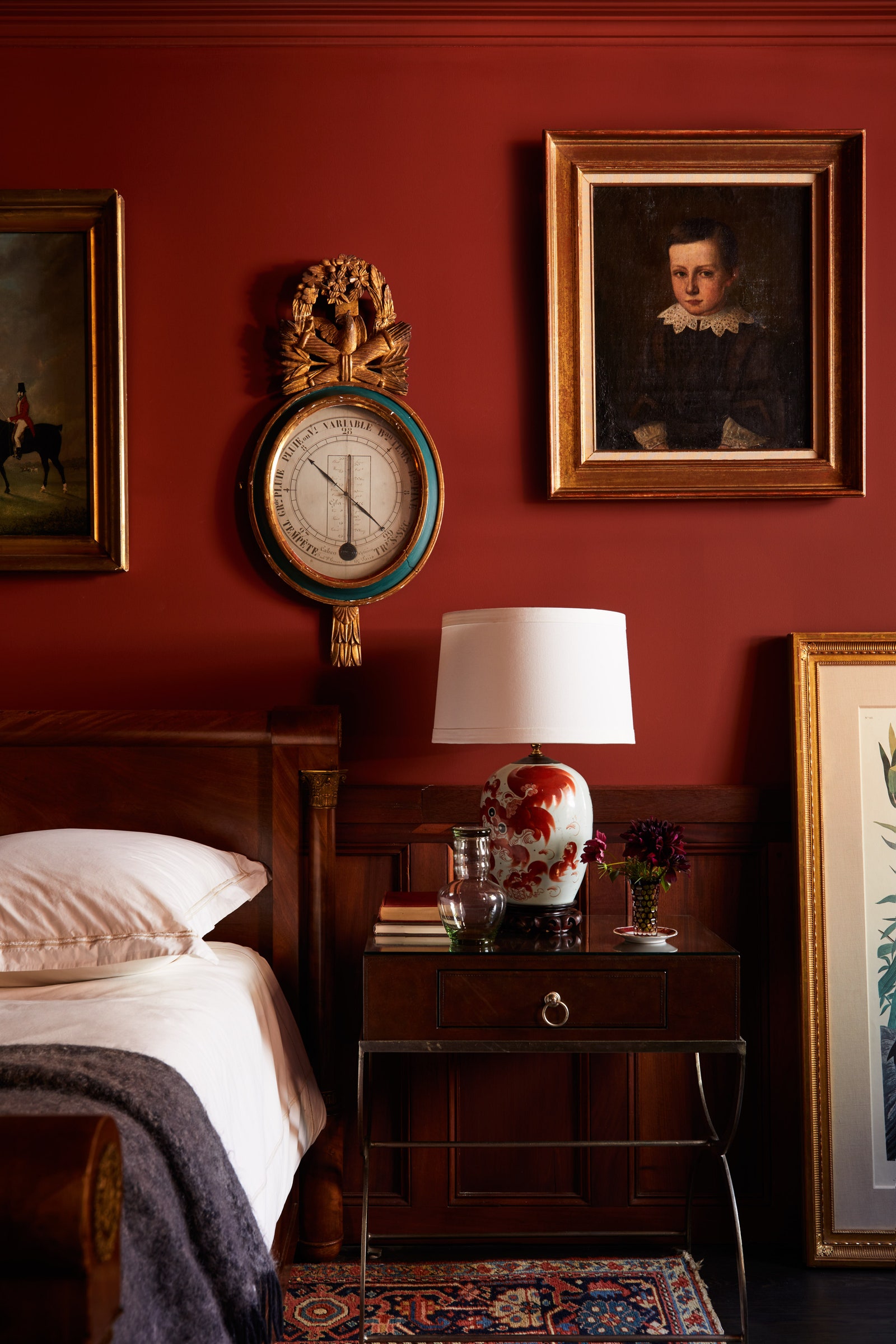 Guest room with red painted walls art antiques
