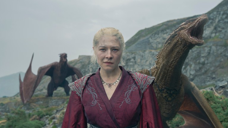 Queen Rhaenyra (Emma D'Arcy) stands near Dragonstone surrounded by dragons