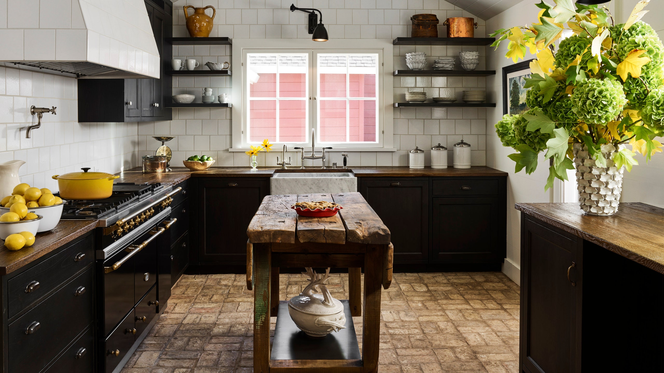 a black and white kitchen with a rustic antique central island made of wood