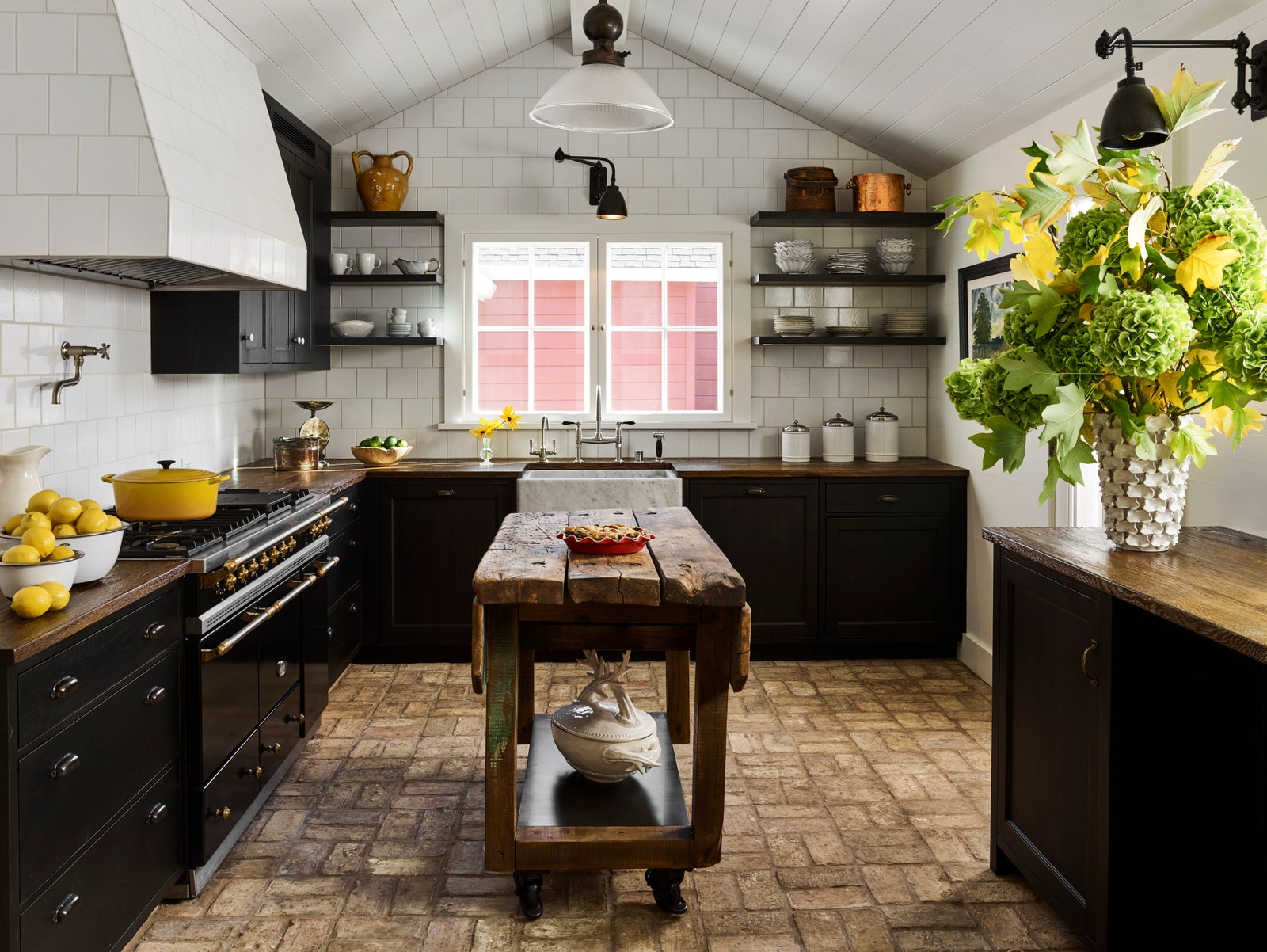 a black and white kitchen with a rustic antique central island made of wood