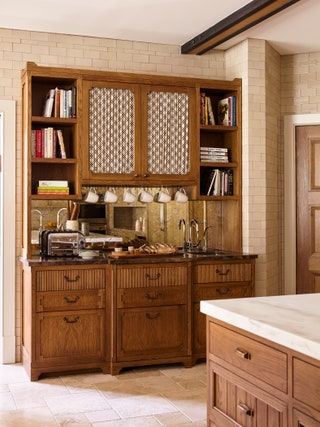 Shirred panels are paired with inset wiremesh cabinetry to create an elegant facade that discreetly conceals shelf...